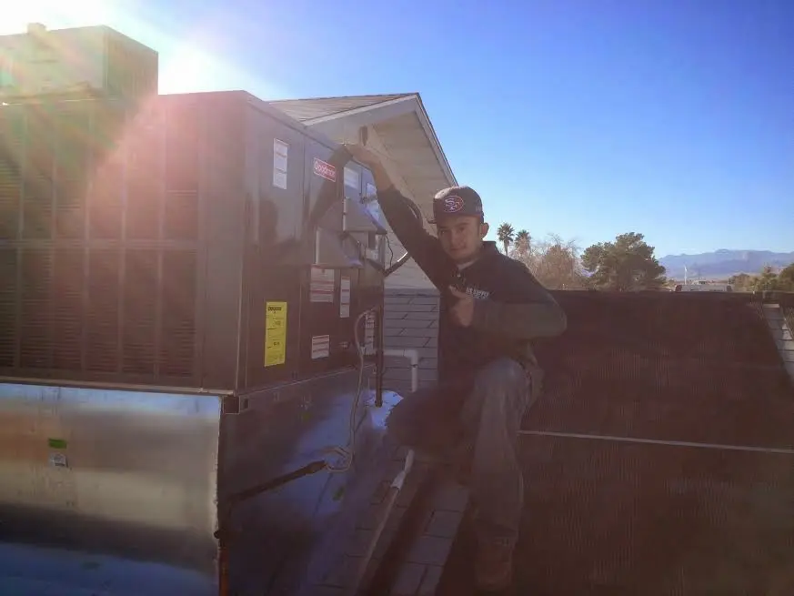 HVAC technician performing HVAC Inspection on a rooftop unit in Enumclaw